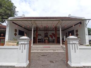 a house with a pavilion with a patio at Mruyung Guest House Kota Lama Banyumas Mitra RedDoorz in Banyumas