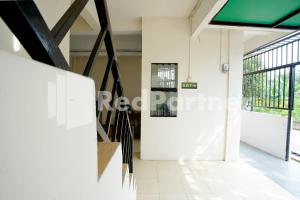 pasillo de un edificio con puerta y ventanas en Vania Guesthouse near RS Adam Malik Medan RedPartner, en Medan