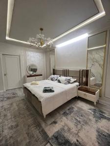 um quarto com uma cama grande e um lustre em lux apartment in tashkent city em Tashkent