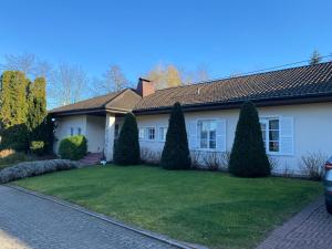 ein weißes Haus mit Bäumen im Hof in der Unterkunft Gästehaus Scholly in Saarlouis