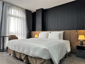sypialnia z dużym łóżkiem z białą pościelą w obiekcie La Maison Boutique Hotel w mieście Cao Bằng