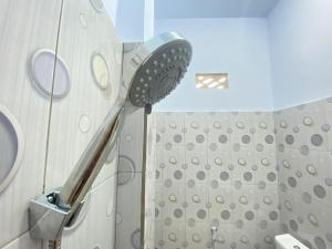a bathroom with a shower with a shower head at Kanaan Guesthouse RedPartner in Manado