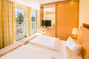 a hotel room with a bed and a television at Castello Apartments in Lüneburg