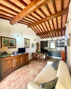 a living room with a white couch and a kitchen at Agriturismo Rosa dei Venti in Pomarance