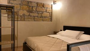 um quarto com uma cama e uma parede de tijolos em Palazzo Liberty em Monreale