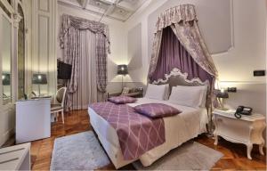 1 dormitorio con 1 cama extragrande con dosel púrpura en Best Western Plus Hotel Genova, en Turín
