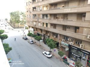 een straat in de stad met auto's naast een gebouw bij Golden Star Hostel in Caïro