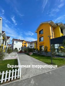 a row of houses on a street with a yellow building at Promenade Burabay халал-апартаменты in Borovoye