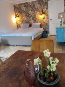 a bedroom with a bed and a table with flowers on it at Appartement Juf in Lisse