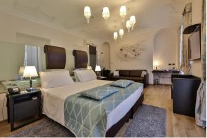 Best Western Plus Hotel Genova في تورينو: غرفة نوم بسرير كبير وغرفة معيشة
