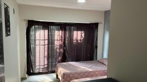a bedroom with a bed and a window with curtains at SaVilie 1 - Seguridad y Comfort in Guadalajara