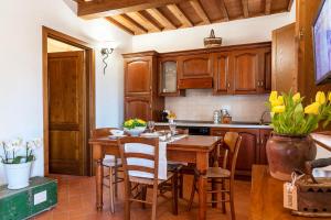 cocina con mesa de madera y sillas en Il Cerreto, en La Pesta