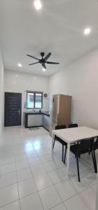 a kitchen with a table and a ceiling fan at Mersing little homestay II in Mersing +1 photo
