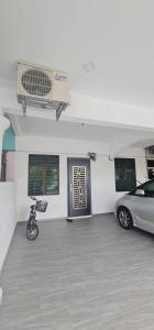 a garage with a car and a motorcycle parked in it at Mersing little homestay II in Mersing