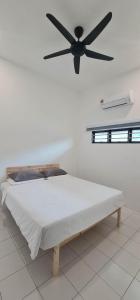 a bedroom with a bed with a ceiling fan at Mersing little homestay II in Mersing