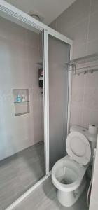 a bathroom with a white toilet and a shower at Mersing little homestay II in Mersing