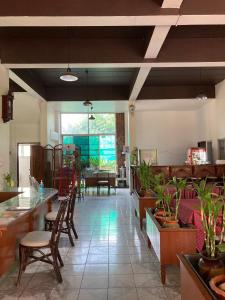 a living room with chairs and tables and a room with plants at Wiriya House in Chiang Mai