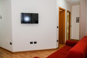 a living room with a red couch and a tv on a wall at AF Apartments in Vibo Valentia Marina