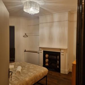 a room with a fireplace and a table and a chandelier at 41 Crawley Road in Luton