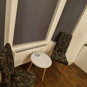 a room with two chairs and a table at 41 Crawley Road in Luton