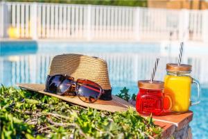 un chapeau de paille et des lunettes de soleil assis à côté d'une piscine dans l'établissement Le Domaine du Thronnet, à Figanières