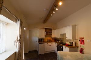 a kitchen with white cabinets and a counter top at Pant Teg B & B in Bangor