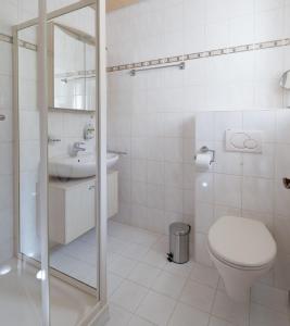 a white bathroom with a toilet and a sink at Ferienwohnung „Prims“ in Wadern
