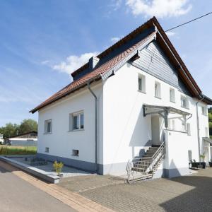 a white building with a red roof at Ferienwohnung „Prims“ in Wadern