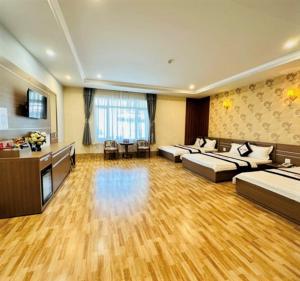 una camera d'albergo con due letti e un soggiorno di Khách sạn Ngọc Thành 2 a Rach Gia