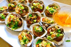 a plate of oysters on a table with a drink at Khách Sạn Hồng Tấn in Thương Xà (2)