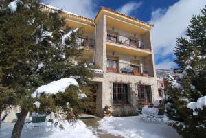 Vega del CadornoHotel Restaurante Rio Cuervo的前面有雪的大建筑