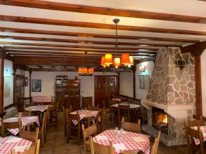 Vega del CadornoにあるHotel Restaurante Rio Cuervoのテーブルと椅子、暖炉のあるレストラン