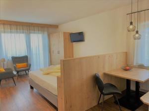 a bedroom with a bed and a table and chairs at Garni Winklerhof in Lagundo
