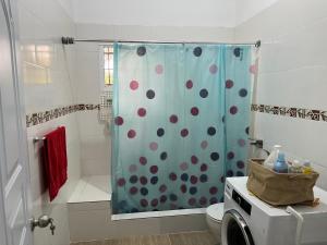 y baño con ducha con cortina de polka. en Villa Piña Alojamiento rural, 