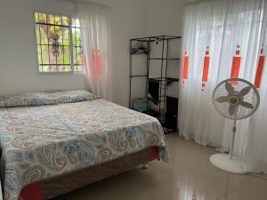 - une chambre avec un lit, un ventilateur et une fenêtre dans l'établissement Villa Piña Alojamiento rural, 