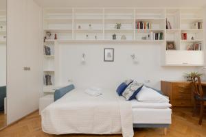 a white bedroom with a bed and a desk at Koszykowa Sunny Studio by Renters in Warsaw