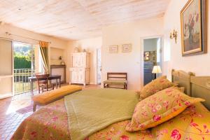 ein Schlafzimmer mit einem großen Bett und einem Tisch in der Unterkunft Le Moulin de la Maison des Templiers in Saint-Cernin-de-Larche