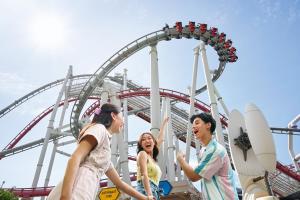 a group of people standing in front of a roller coaster at Resorts World Sentosa - Crockfords Tower in Singapore