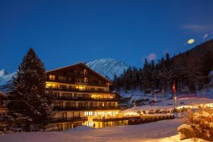 a hotel in the snow at night in the mountains at Hotel Alpin Superior in Saas-Fee