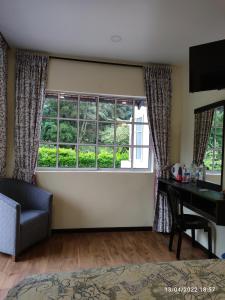 sala de estar con escritorio y ventana en Hillview Inn Cameron Highlands PROMO, en Tanah Rata