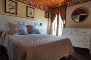 a bedroom with a bed and a dresser and a mirror at Cal Curpets - Bicicletas FREE in Puigvert de Agramunt