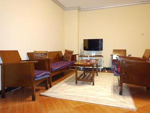 a living room with chairs and a table and a tv at Fully furnished condo in the center of addis ababa in Addis Ababa