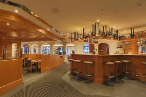 a restaurant with a bar with stools at Hotel Alpin Superior in Saas-Fee