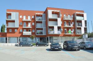 a parking lot with cars parked in front of a building at Apartment Silvija sea view in Umag
