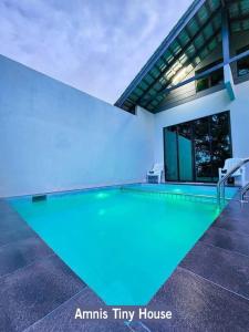 a swimming pool with blue lighting in a house at Amnis Tiny House in Bachok +9 photos