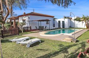 een villa met een zwembad en een huis bij Chalet Verde Agua in Conil de la Frontera