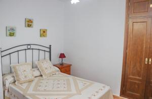 een slaapkamer met een bed en een houten deur bij Chalet Verde Agua in Conil de la Frontera