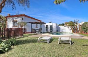 een achtertuin met een zwembad en een huis bij Chalet Verde Agua in Conil de la Frontera