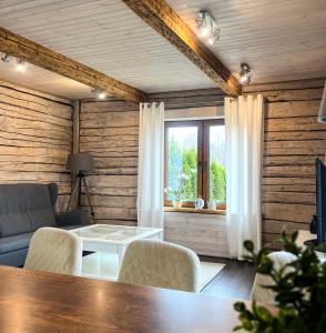 Klaukse في Aabla: غرفة معيشة بجدران خشبية وطاولة وكراسي
