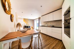 a kitchen with a wooden table and white cabinets at NUITS DE LOIRE -Entre Blois et Chambord in Vineuil